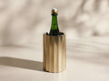Front view of the brass fluted Dayana Wine Chiller holding a green bottle with a cork, showing condensation.
