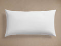 White, plump rectangular decorative lumbar pillow insert, horizontally oriented on a simple beige background.