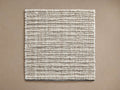 Dover Performance Rug Swatch, square, showing chunky, tightly woven light beige and brown textured fibers, flat on a tan surface.
