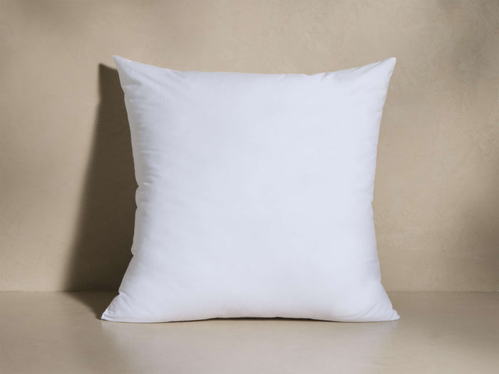 Front view of a white, square pillow insert with soft, slightly pointed corners.