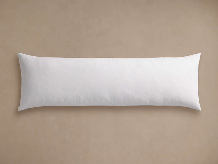White Down Fill Lumbar Pillow Insert, rectangular and soft, lying horizontally on a textured light beige background.