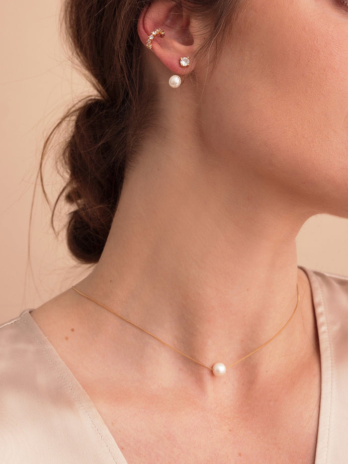 Woman wearing freshwater pearl pendant and earrings