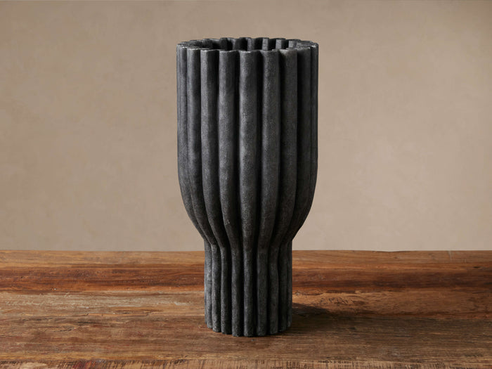 Edel Ruffle Vase, dark gray, textured, with vertical ridges, standing upright on a rustic wooden table.