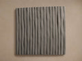 Eden Outdoor Finish Board, a dark gray square panel with vertical wavy ribbed texture, against a light beige wall.