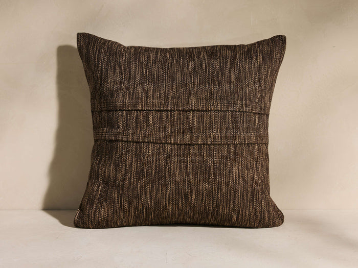 Square Esencia Pleated Pillow in textured dark brown with two horizontal pleats across the center, standing upright.