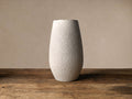 Cream Eva Grand Vase, tall ovoid shape with all-over dimpled texture, standing on a rustic wooden table.