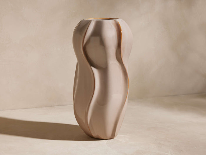 Eva Large Seedpod Vase: a tall, glossy taupe ceramic vase with organic, seedpod-like curves on a light textured surface.