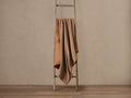 Warm brown Faux Fur Sherpa Throw draped over a wooden ladder, showing soft fur and textured sherpa sides.