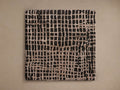 A square rug with an abstract grid pattern in black and light brown colors, displayed on a neutral background.