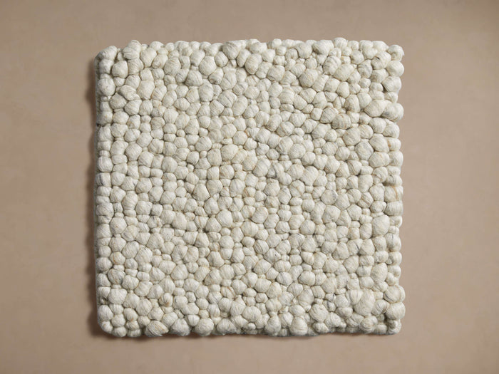 Freemont Rug Swatch: Square, off-white with dense, pebble-like texture on a light beige background.