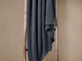 Indigo garment-dyed throw with a luxurious waffle pattern, softly draped over a rustic wooden ladder.