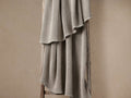 Mink Garment-Dyed Throw with soft waffle texture, draped over a rustic wooden ladder against a neutral beige wall.