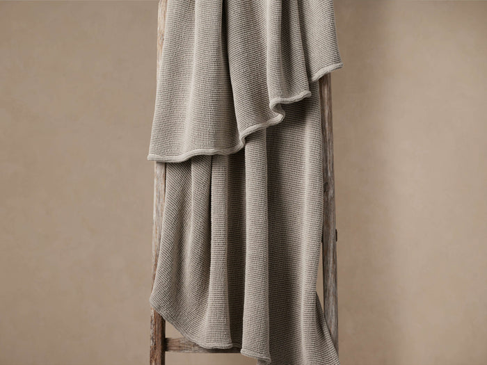 Mink Garment-Dyed Throw with soft waffle texture, draped over a rustic wooden ladder against a neutral beige wall.