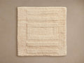 Geo Hand-Knotted Rug Swatch in beige, featuring a textured rectangular pattern with parallel lines, on a neutral background.