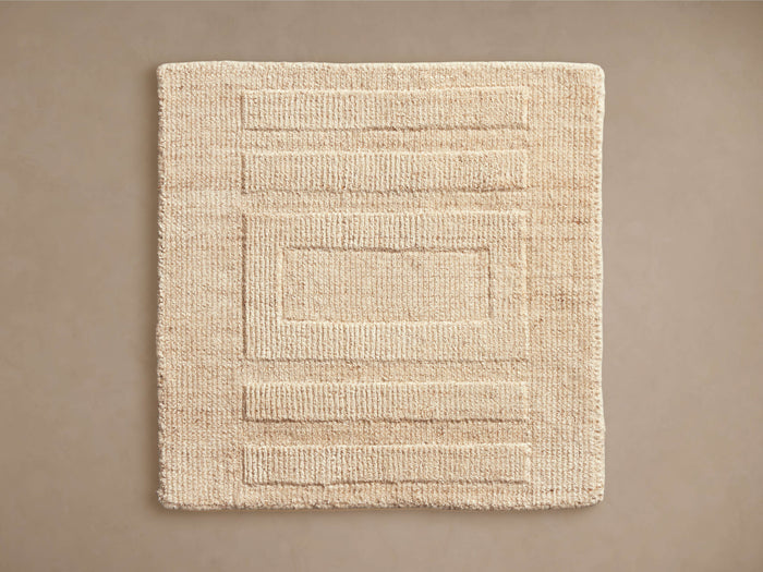 Geo Hand-Knotted Rug Swatch in beige, featuring a textured rectangular pattern with parallel lines, on a neutral background.