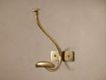 Polished gold brass Grand Chester Hanging Hook with a curved top and smaller lower hook, mounted on a light wall.