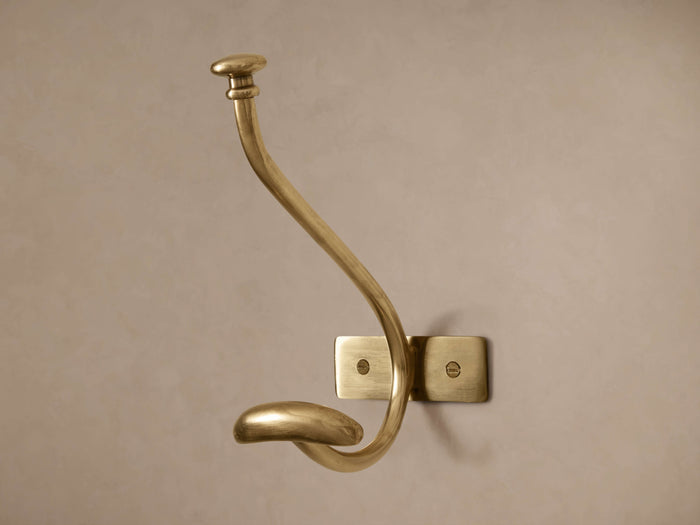 Polished gold brass Grand Chester Hanging Hook with a curved top and smaller lower hook, mounted on a light wall.