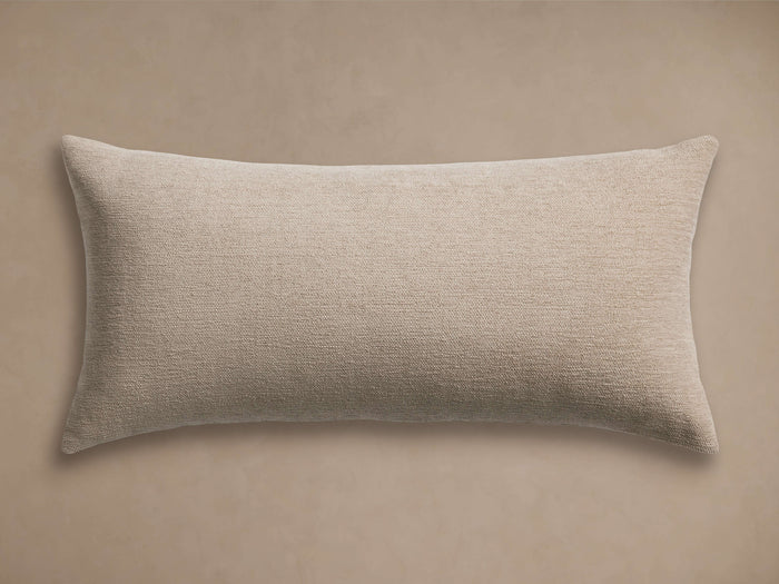 Light beige Granville Outdoor Lumbar Pillow, horizontally oriented, with a subtle woven texture, against a tan background.