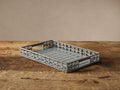 Rectangular Hatteras Serving Tray in grey/white woven material with glass insert, angled on a rustic wooden surface.