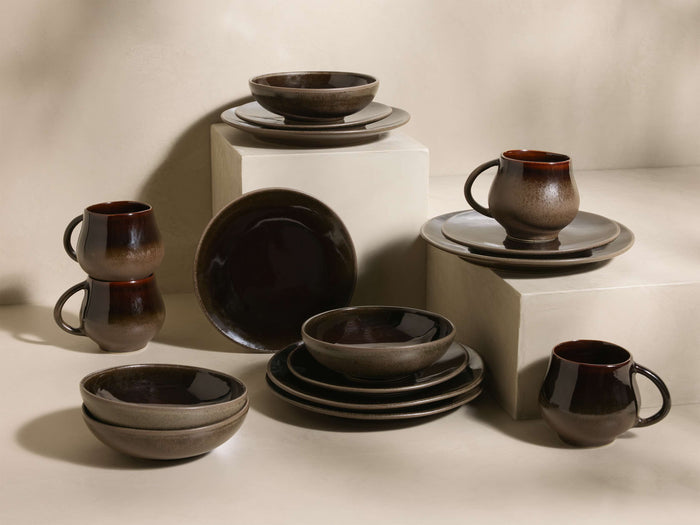 Chocolate and mocha Hearthline Dinnerware With Cereal Bowls (Set of 16), featuring reactive glaze mugs, bowls, and plates.