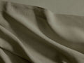 Close-up of olive green Italian Garment-Dyed Linen Flat Sheet, showing its textured fabric, soft folds, and a prominent hem.