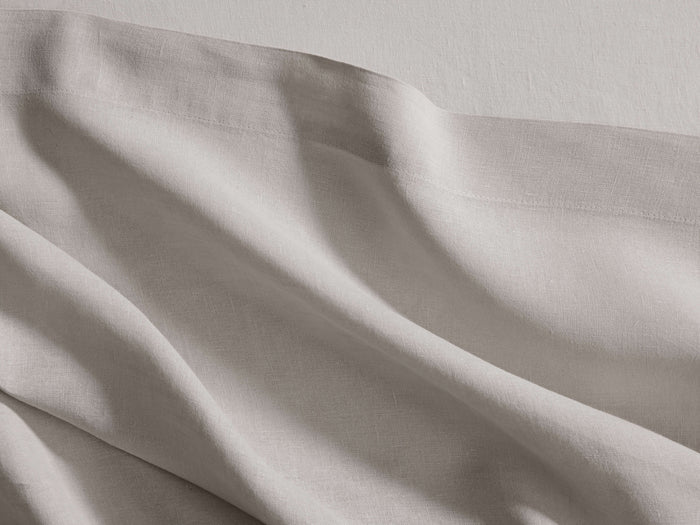Italian Garment-Dyed Linen King Flat Sheet in Natural, casually draped, revealing soft folds, subtle texture, and a visible hem.