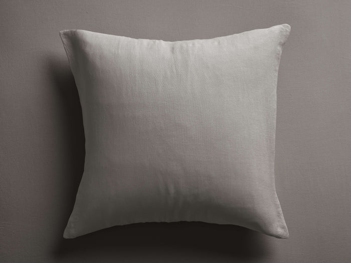 Square Italian Garment-Dyed Linen Sham in mink, centered on a textured dark gray background, highlighting its soft linen.
