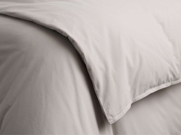 Close-up of a natural Italian Garment-Dyed Percale Duvet, showing soft folds and subtle, garment-dyed texture.