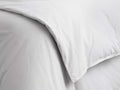 Close-up of a white Italian Garment-Dyed Percale Duvet, softly folded with natural creases, highlighting its relaxed texture.