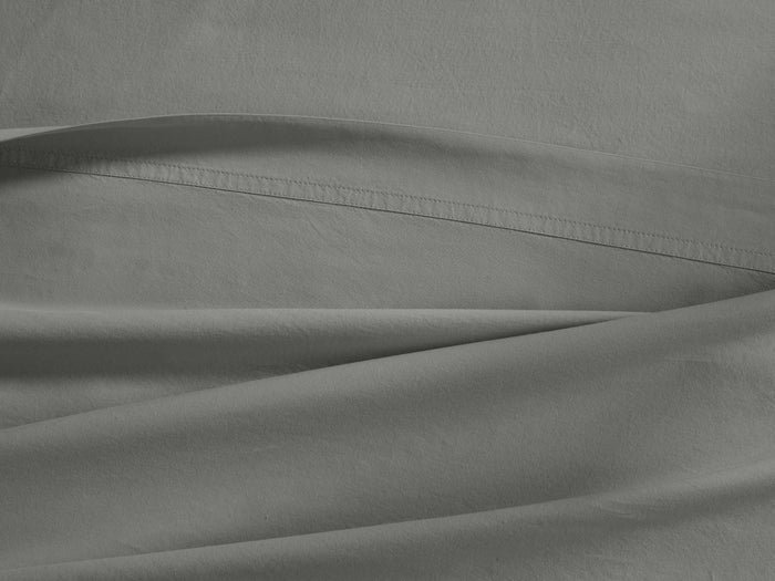 Close-up of a gray Italian Garment-Dyed Percale Flat Sheet with subtle texture and a visible top hem, draped softly.