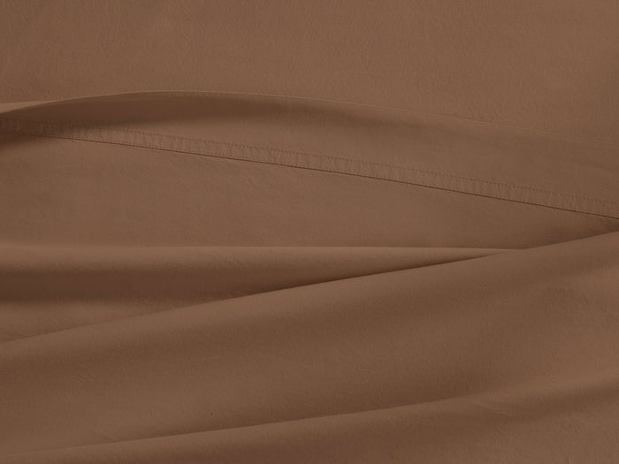 Clay Italian Garment-Dyed Percale Flat Sheet, draped with soft folds and a visible stitched hem, showing its rich, warm brown color.