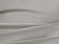 Close-up of a light gray Italian Garment-Dyed Percale Flat Sheet, showing a clean hem and natural fabric folds.