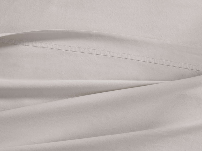 Natural Italian Garment-Dyed Percale Flat Sheet, draped with a visible 1 ??" hemline and fine stitching.