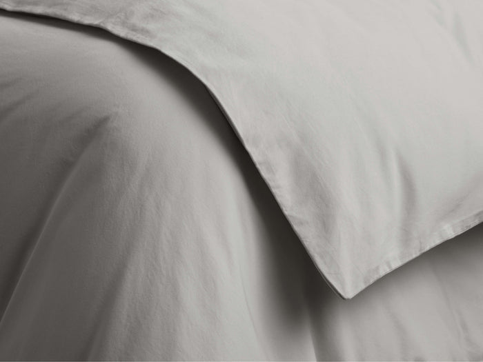 Close-up of light grey Italian Garment-Dyed Sateen Duvet, showing soft, subtly wrinkled fabric with a folded edge.
