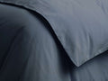Close-up of a deep blue-grey Italian Garment-Dyed Sateen Duvet, showing soft, flowing fabric and a subtle sheen.