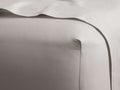 Natural Italian Garment-Dyed Sateen Fitted Sheet, close-up showing silky smooth fabric with subtle sheen, fitted to a mattress.