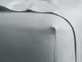 Sky Italian Garment-Dyed Sateen Fitted Sheet smoothly covering a mattress corner, with a soft sheen and folded top edge.