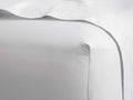 White Italian Garment-Dyed Sateen Fitted Sheet, showcasing a crisp, fitted corner and soft, subtle sheen.