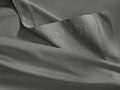 Charcoal gray Italian Garment-Dyed Sateen Flat Sheet, folded to show its soft texture, subtle sheen, and fine hem stitching.