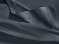 Dark blue Italian sateen flat sheet, folded, showing a wide hem with stitching and soft, flowing fabric.