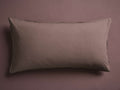 A rectangular, taupe pillow with smooth fabric and subtle stitching, placed flat against a matching taupe background.