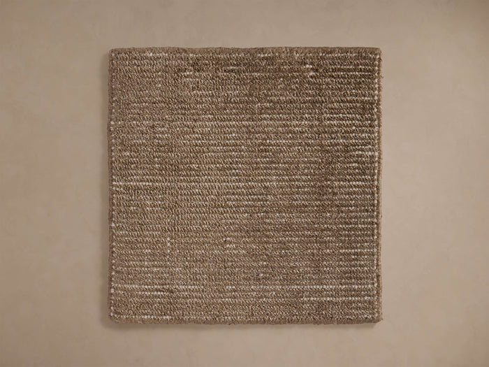 Jackson Rug Swatch, a textured square swatch of handwoven brown and white fibers, laid flat on a light beige surface.