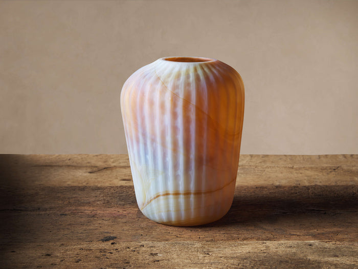 Hand-blown Jasper Vase with milky white, orange, and brown swirled glass and vertical ribs, on a rustic wood surface.