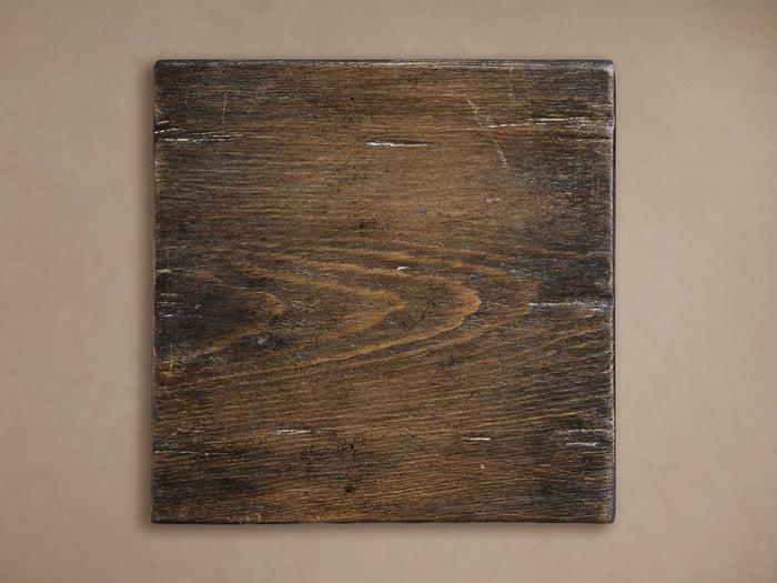 Square dark brown Kai Finish Board with wood grain texture and light scuff marks, against a beige background.