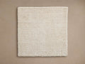 Lanning Rug Swatch in beige, square shape, textured weave, displayed on neutral background, showcasing color and construction.