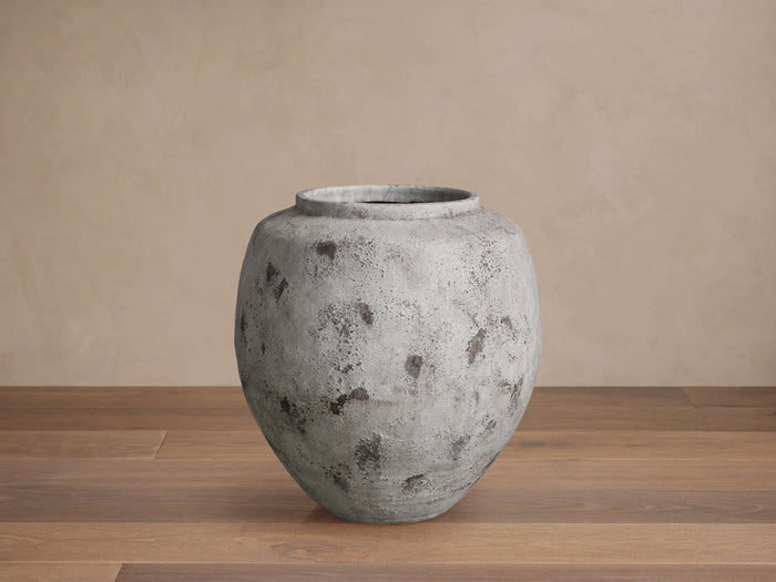 Large Rustic Grey Vessel, round handcrafted terracotta vase with a distressed finish & dark splotches, on a wooden floor.