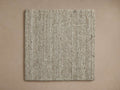 Lassen Rug Swatch: Light beige, square, handwoven natural fiber rug sample with visible texture, centered on a tan background.
