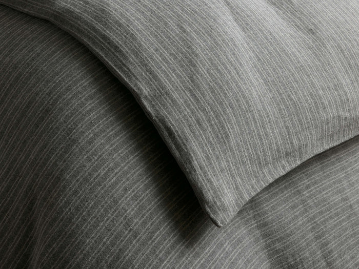 Close-up of a textured grey Laviss Stripe Duvet with thin white vertical stripes, showing soft folds and creases.