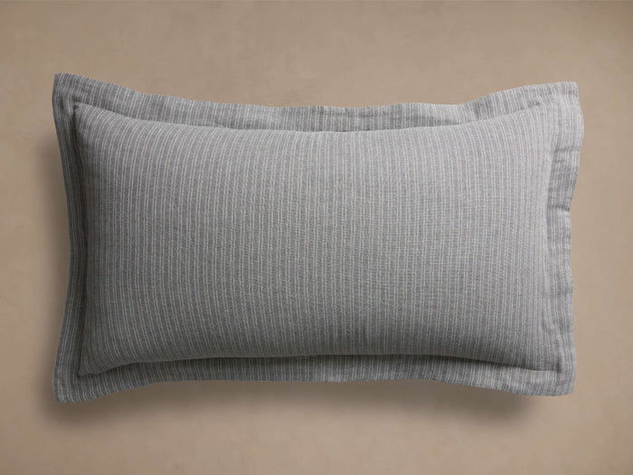 Laviss Stripe Sham, gray with fine vertical white stripes, rectangular, flanged edge, centered on a light brown background.
