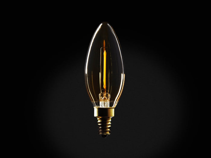 Front view of a clear, glowing candle-shaped LED filament bulb with a warm yellow light and brass screw base.